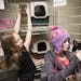 Twin sisters Abby, left, and Isabelle Carlsen play with cats at the Central Dakota Humane Society.