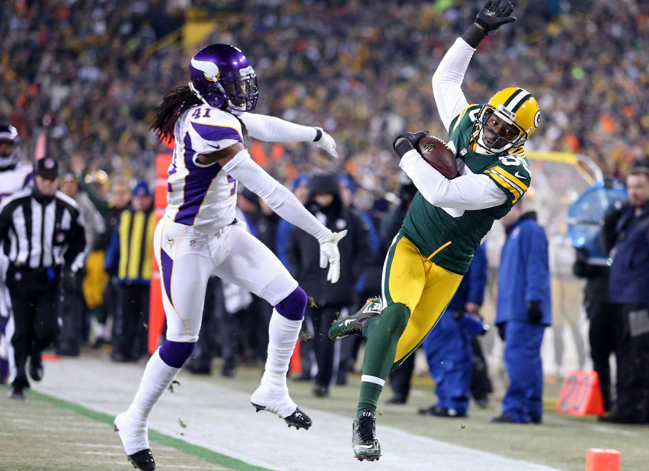Green Bay Packers wide receiver Greg Jennings, right, gets pushed out of bounds by Minnesota Vikings safety Mistral Raymond