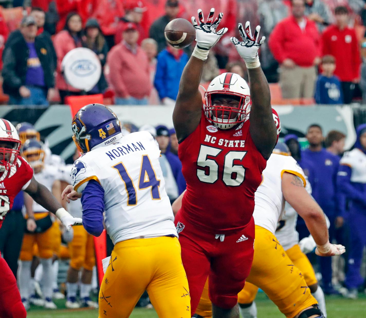 North Carolina State's Val Martin (56) pressures East Carolina's Caiden Norman (14) during the second half of an NCAA college football game in Raleigh, N.C., Saturday, Dec. 1, 2018. (AP Photo/Chris Seward)