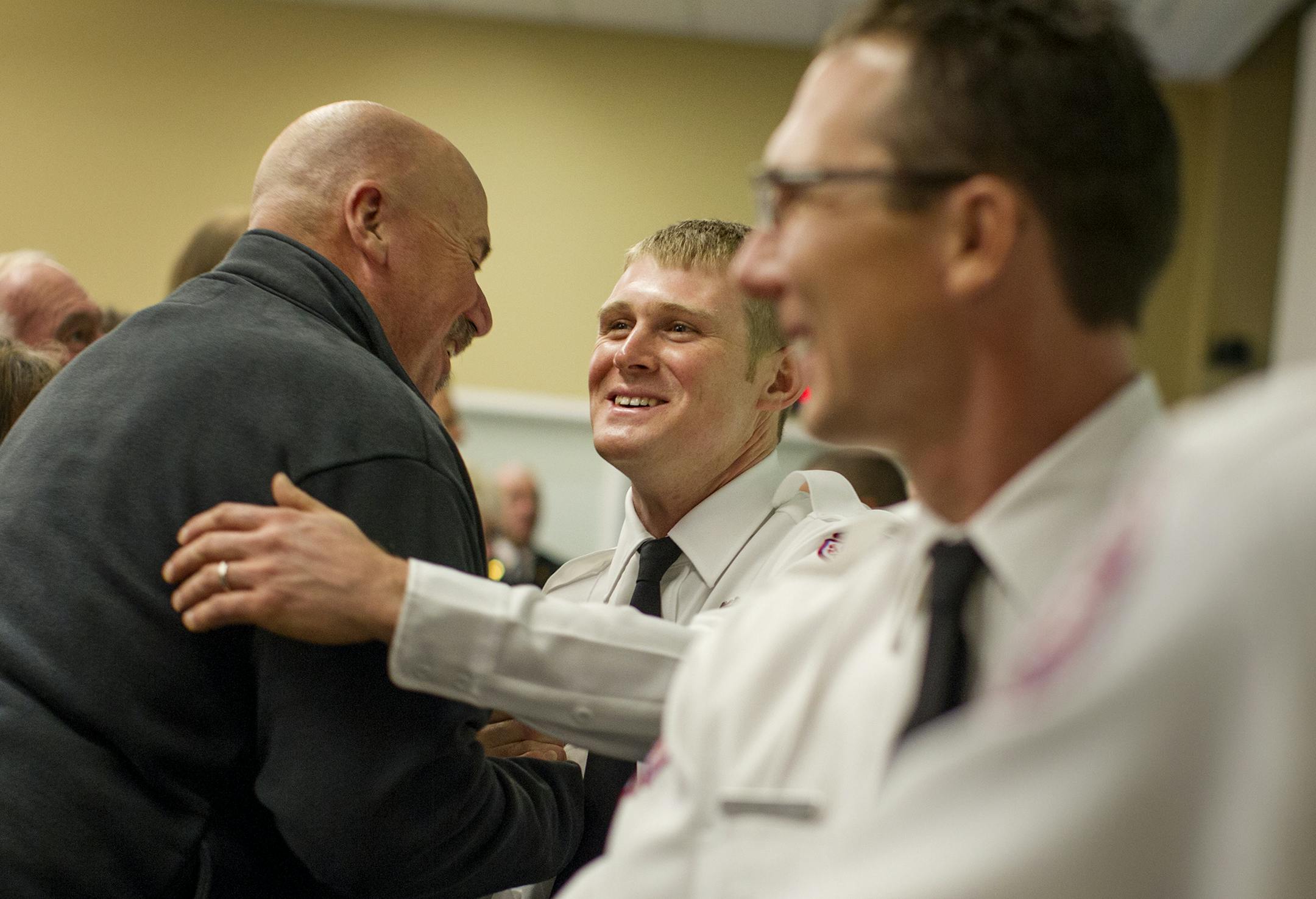 Hennepin Technical College fire faculty member Jack Myers, left, congratulated Matthew Unklesbay and nine other cadets at the graduation ceremony.