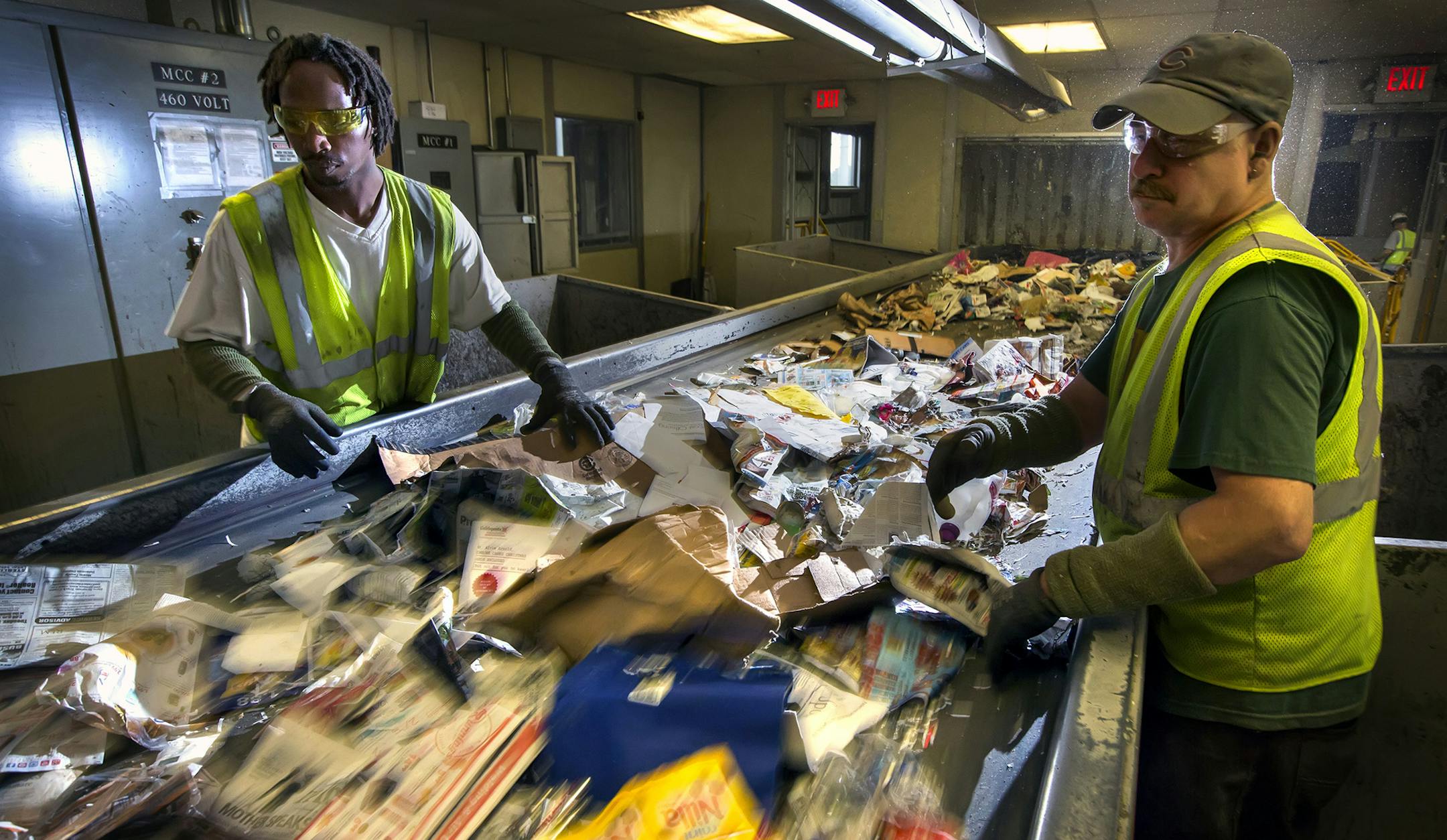 Jerrell Stewart (left) and Martin Kellers (right) work the sort line at Dem-Con recycling facility in Shakopee. ] Global economic trends are putting a squeeze on the big blue bin. Metro area cities accustomed to earning money from the processing of recyclables are suddenly having to pay -- a consequence of rock bottom oil prices and a slowing Chinese economy. The tumbling price for plastics and other materials is taking a toll on the local and recycling market. If trends don't improve, recycling