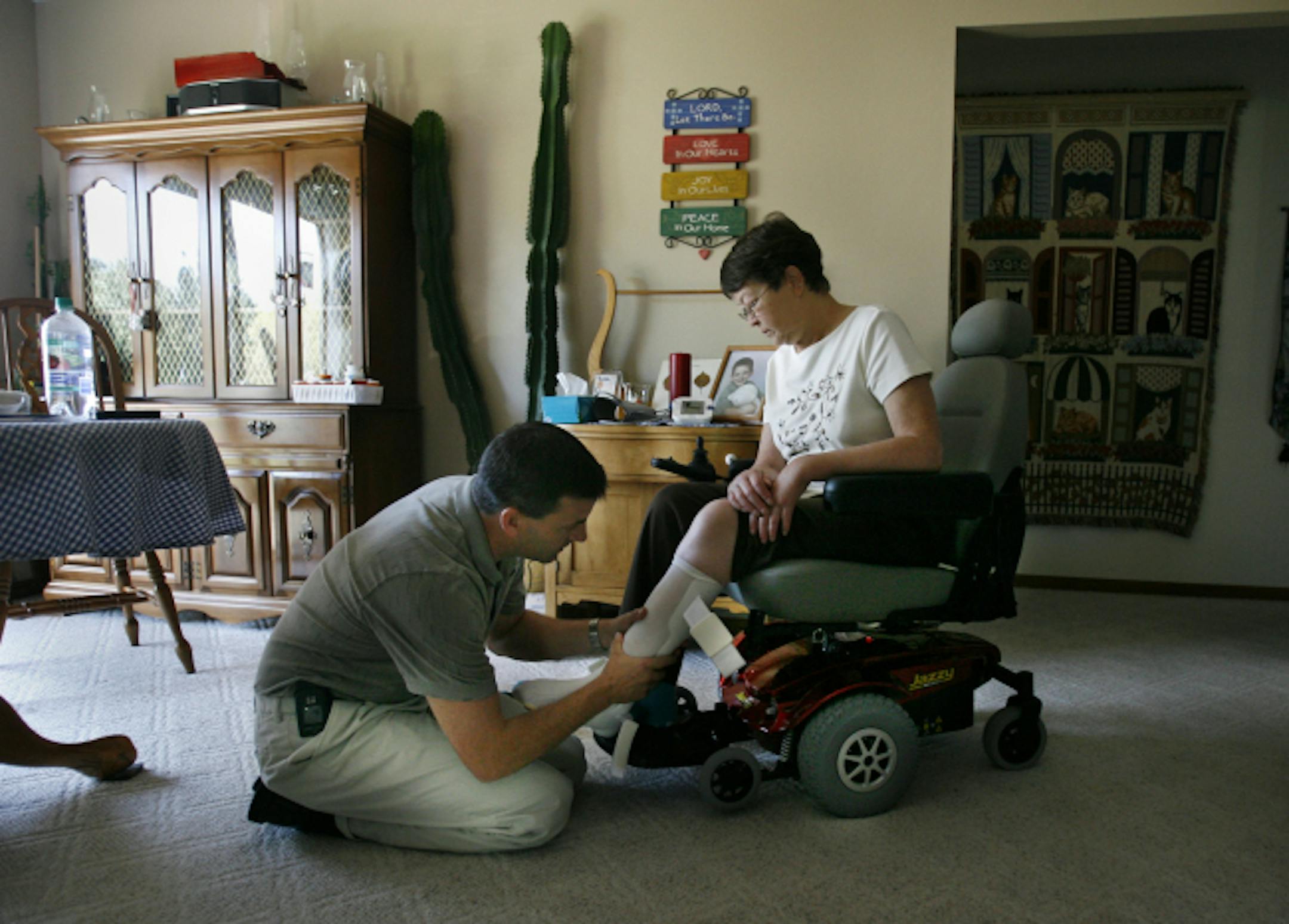 Janyce Laabs, 65, who is diabetic and lost mobility after suffering small strokes, was fitted for leg braces by Tim Theisen, a physical therapist assistant. Through Sibley Medical Center Home Care, Laabs is regularly visited by health care workers where she lives in Arlington, Minn., allowing her to live in her home.