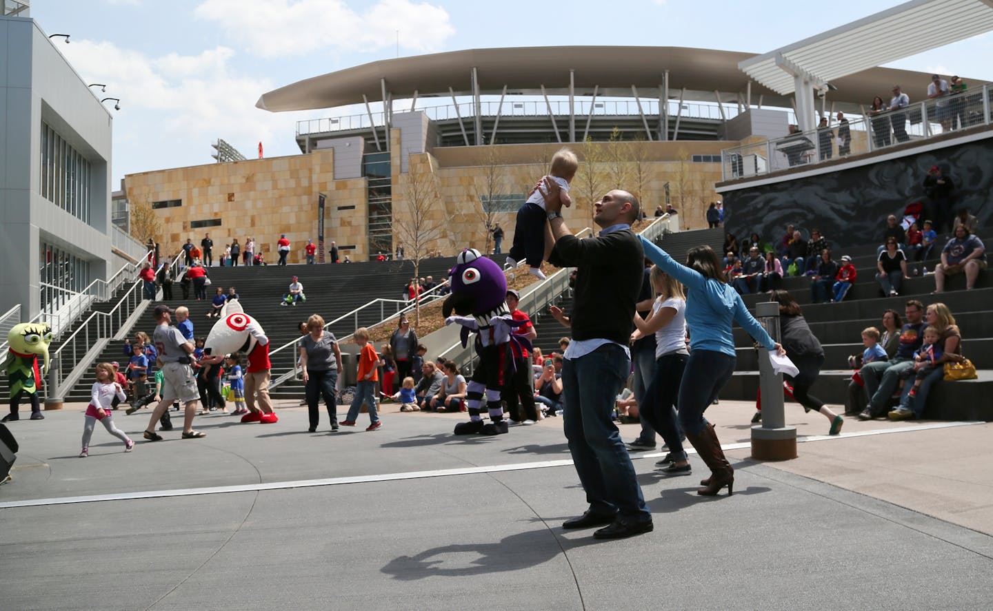 Michael Imranyi, one of the project's architects, danced with his son Aiden, 9 months, during the dedication of the Target Field Station in May.