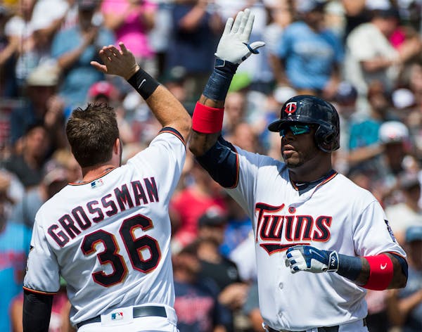 Minnesota Twins designated hitter Kennys Vargas (19) high-fived left fielder Robbie Grossman (36) as he crossed the plate after Vargas hit a two-run h