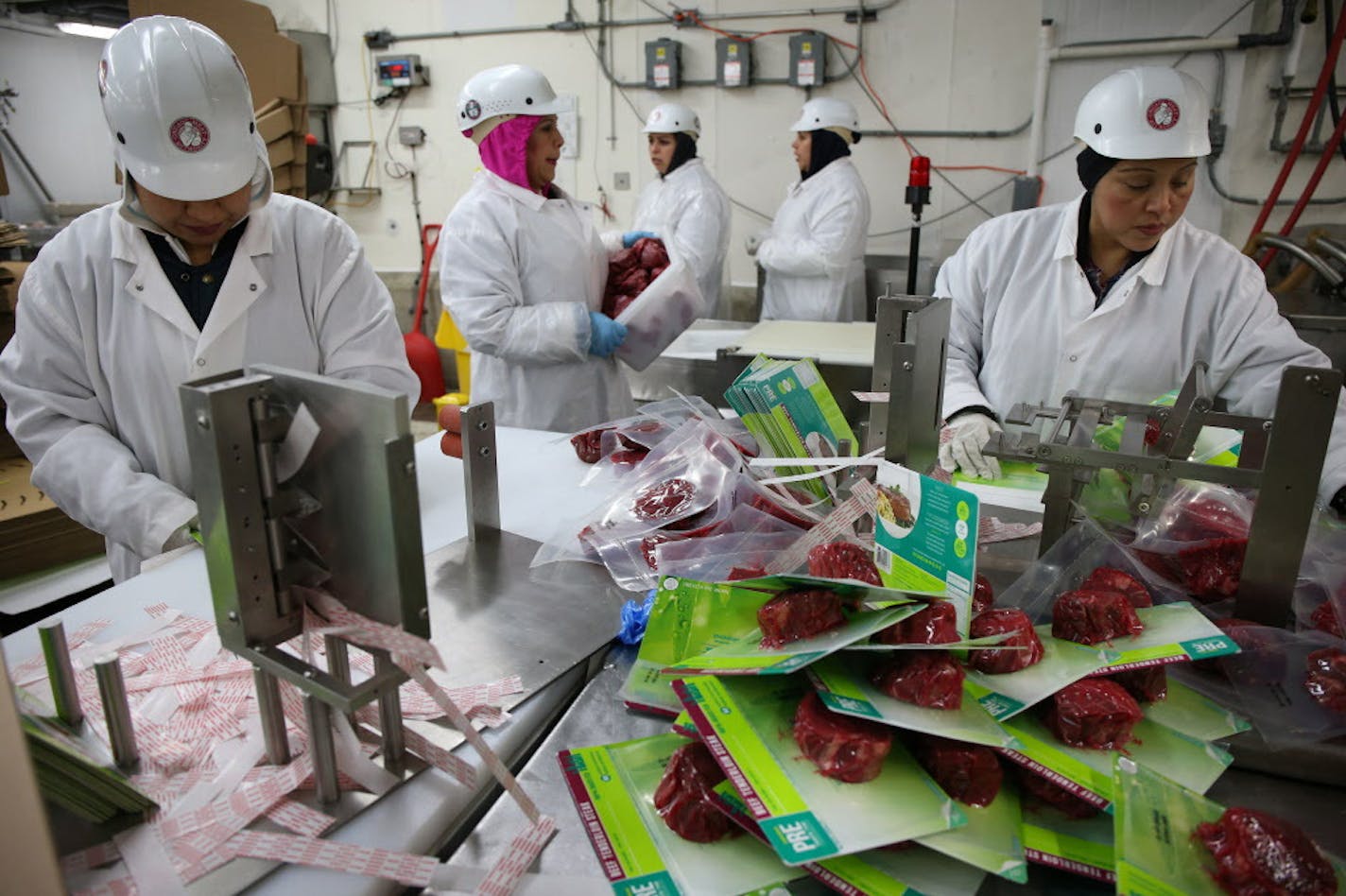 Rosalva Gusman, left, and Siria Hernandez, right, package cuts of beef on April 4, 2016, at Chicago Meat Authority for PRE Brands, which offers 100 percent grass-fed beef. PRE Brands has a contract with Chicago Meat Authority. (Terrence Antonio James/Chicago Tribune/TNS) ORG XMIT: 1183254