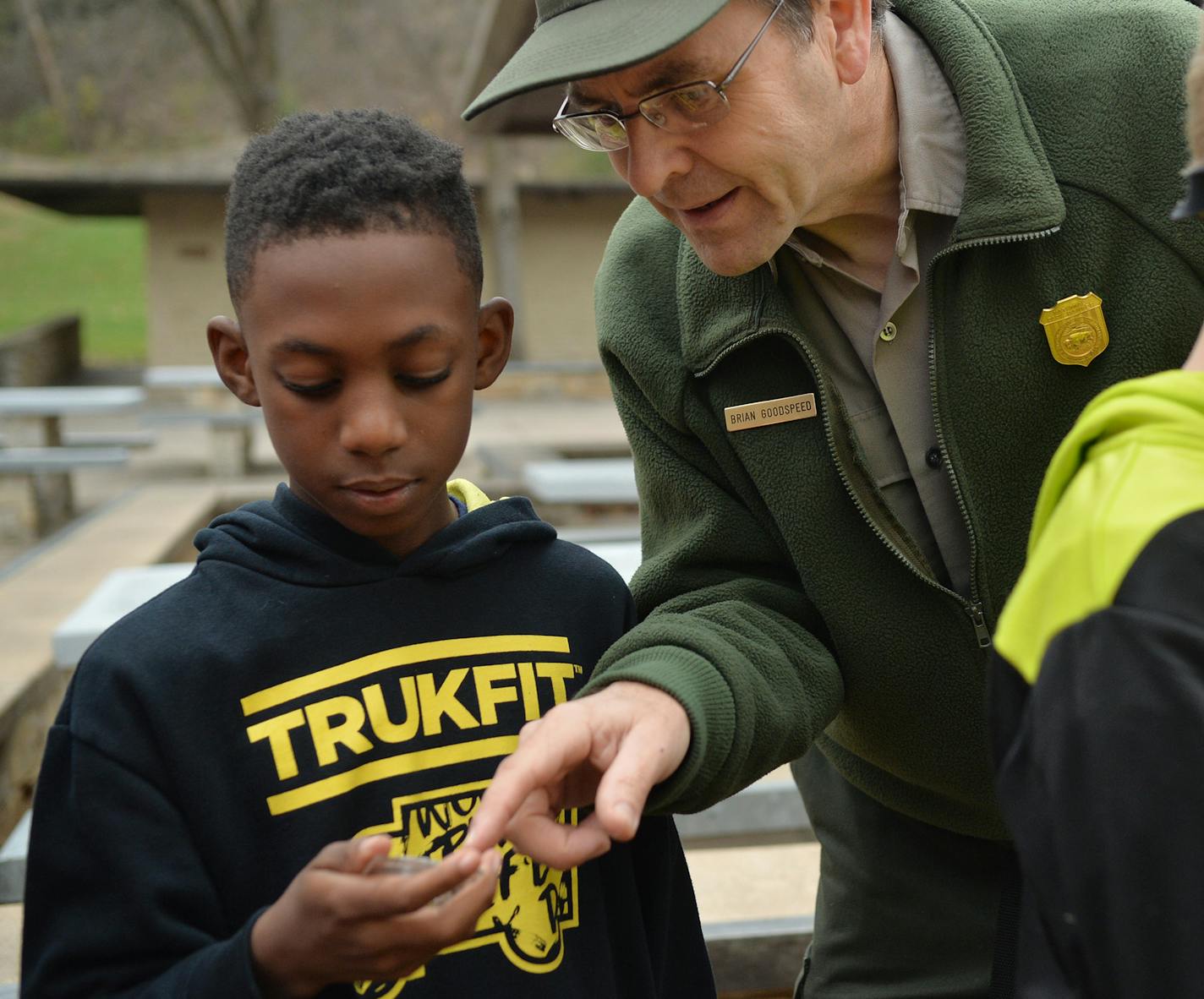 National Park Service Ranger, Brian Goodspeed, explains to Heights Community School fifth grader Xzavion Martin how to use a compass for geocaching in Hidden Falls Regional Park in St. Paul. ] (SPECIAL TO THE STAR TRIBUNE/BRE McGEE) **Brian Goodspeed (National Park Service Ranger), Xzavion Martin (fifth grader, Heights Community School)