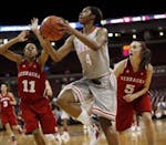 Ohio State's Tayler Hill (4) drove to the basket as Nebraska's Meghin Williams (11) and Kaitlyn Burke (5) defended during the first half Thursday. Hil