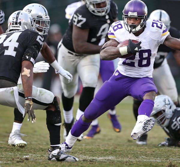Minnesota Vikings running back Adrian Peterson (28) ran away from Raiders free safety Charles Woodson (24) and cornerback D.J. Hayden (25) at the Oakl