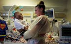 Ke'aiden Proctor plays with his nurse Elizabeth Crank as they get ready for the process of moving him to his second birthday party on Saturday, Nov. 1