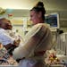 Ke'aiden Proctor plays with his nurse Elizabeth Crank as they get ready for the process of moving him to his second birthday party on Saturday, Nov. 1