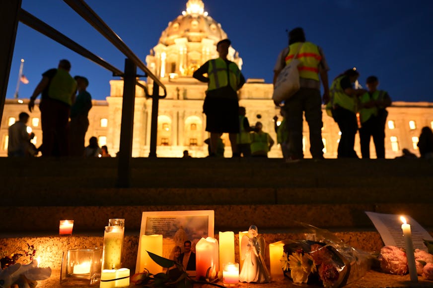 Candles, photos and flowers are left on June 18 at the Minnesota State Capitol during a candlelight vigil for Melissa and Mark Hortman, who were killed in what officials have called a targeted act of political violence.