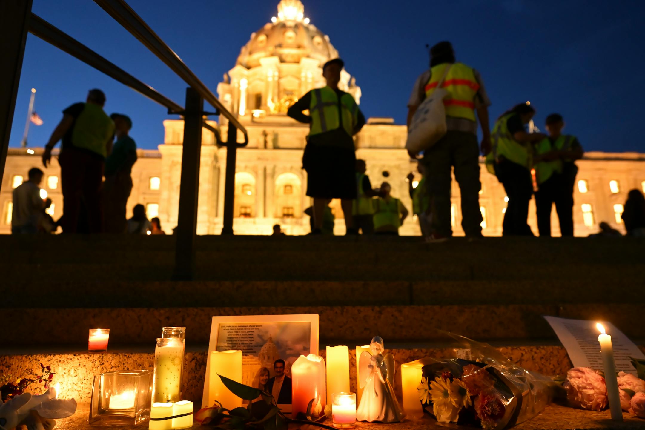 Candles, photos and flowers are left on June 18 at the Minnesota State Capitol during a candlelight vigil for Melissa and Mark Hortman, who were killed in what officials have called a targeted act of political violence.