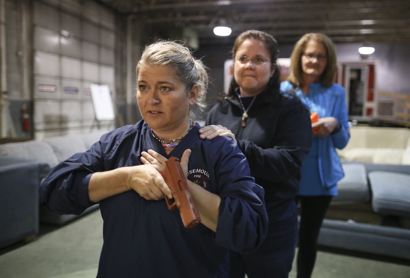 Shelly Anderson, Patti Drew and Judy Hayes, from left, practiced searching a building for an assailant, using plastic guns.