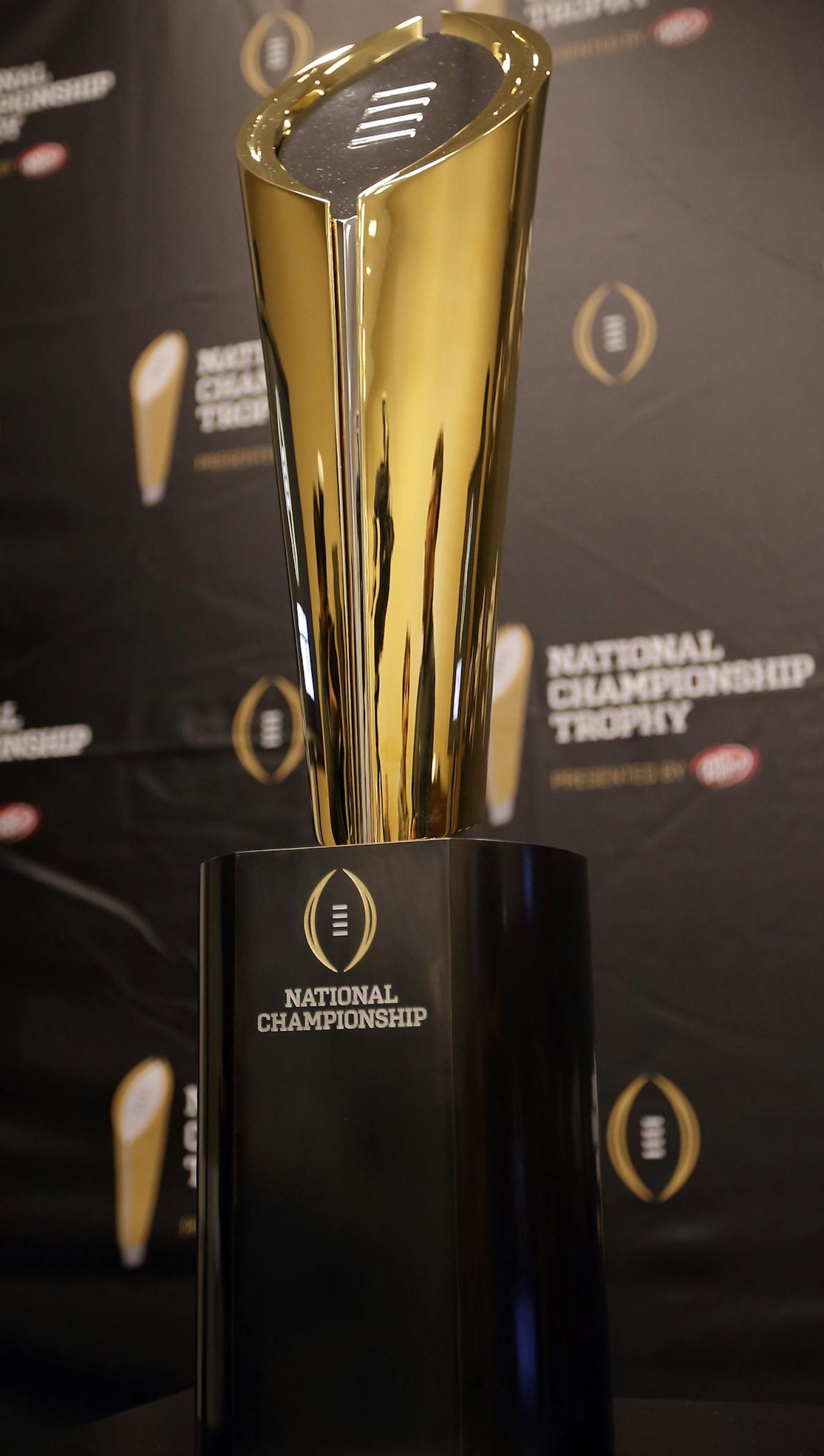 This Monday, July 14, 2014 photo shows the College Football Playoff National Championship Trophy in Irving, Texas. A rising gold football-shaped trophy will be the prize for the national champion in the new College Football Playoff. (AP Photo/Tony Gutierrez) ORG XMIT: NYOTK