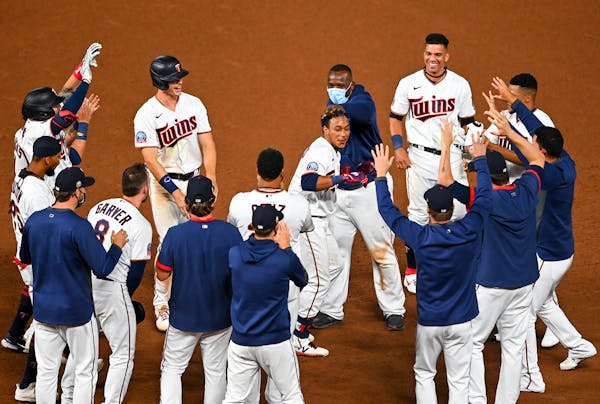 Teammates celebrated a walk-off RBI hit by Minnesota Twins shortstop Jorge Polanco (11) in the bottom of the 12th inning against the Milwaukee Brewers