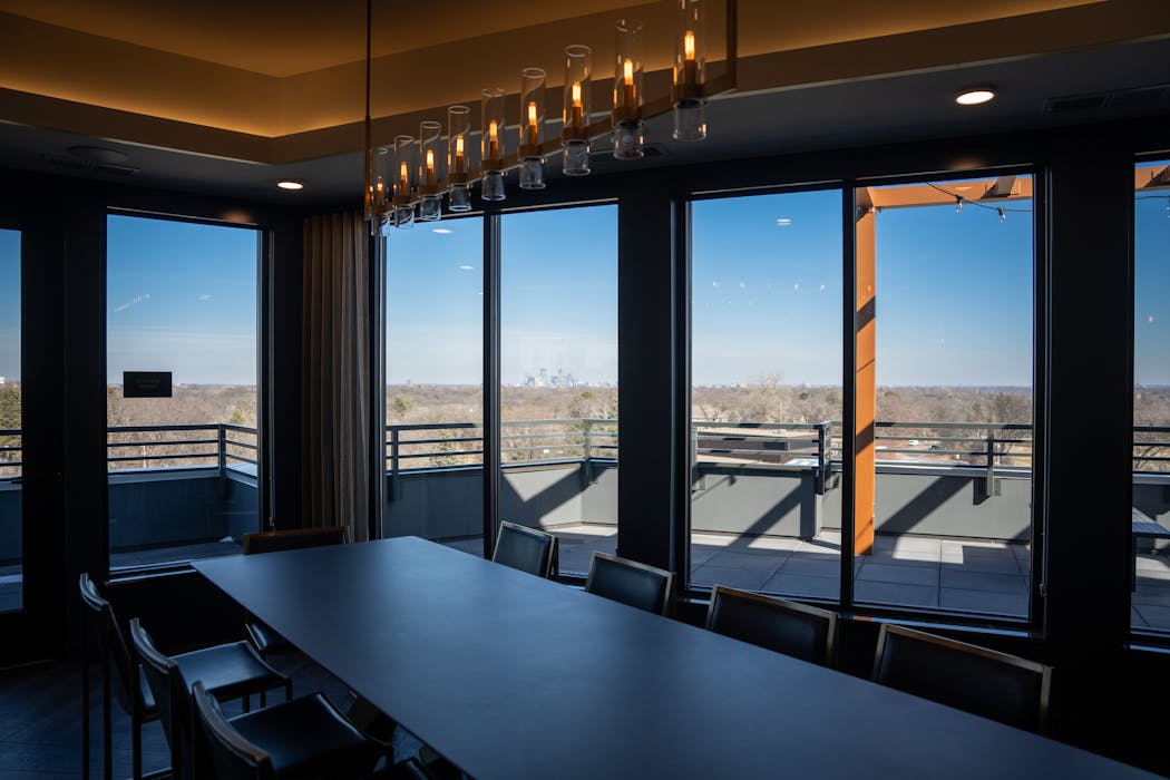 The downtown Minneapolis skyline can be seen from a common meeting room at Maison Green in Edina.