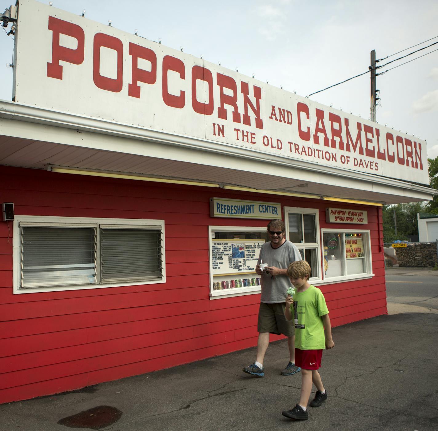 Liam McDonald, 9, and his father, Eddie McDonald, of Minneapolis, eat mint chocolate chip ice cream from Dave's Popcorn in Minneapolis, Minn., Thursday, July 2, 2015. Dave's has been open since 1957 and recently went up for sale.] KAYLEE EVERLY kaylee.everly@startribune.com