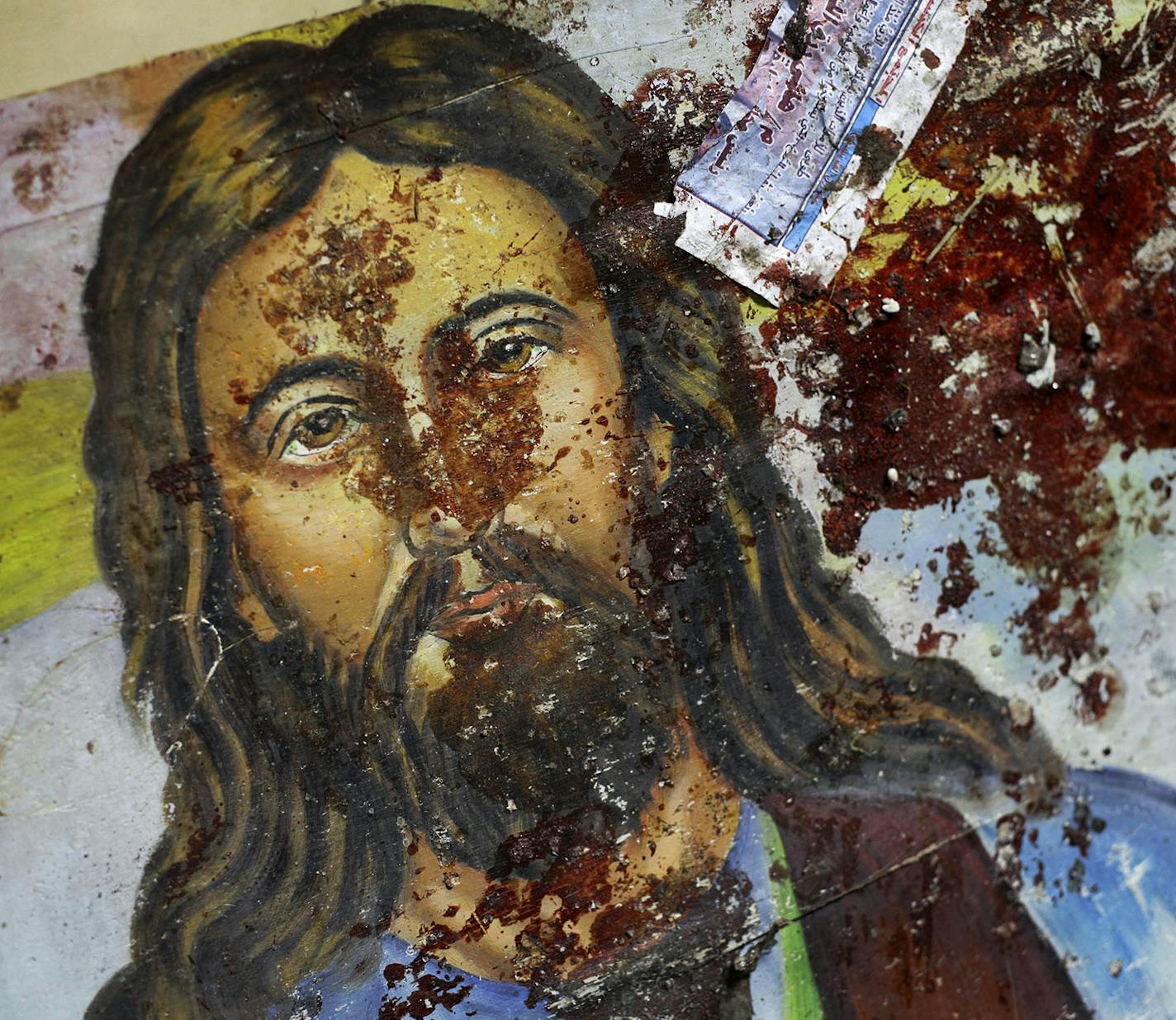 A blood-spattered poster of Jesus Christ is seen inside the the Coptic Christian Saints Church in the Mediterranean port city of Alexandria, Egypt Saturday, Jan. 1, 2011. A car exploded in front of the church early Saturday as worshippers emerged from a New Year's Mass, killing at least 21 people according to officials, and sparking clashes between Christians and Muslims _ a sign of the sectarian anger that has been arising with greater frequency in Egypt. (AP Photo/Ben Curtis) ORG XMIT: MIN2015