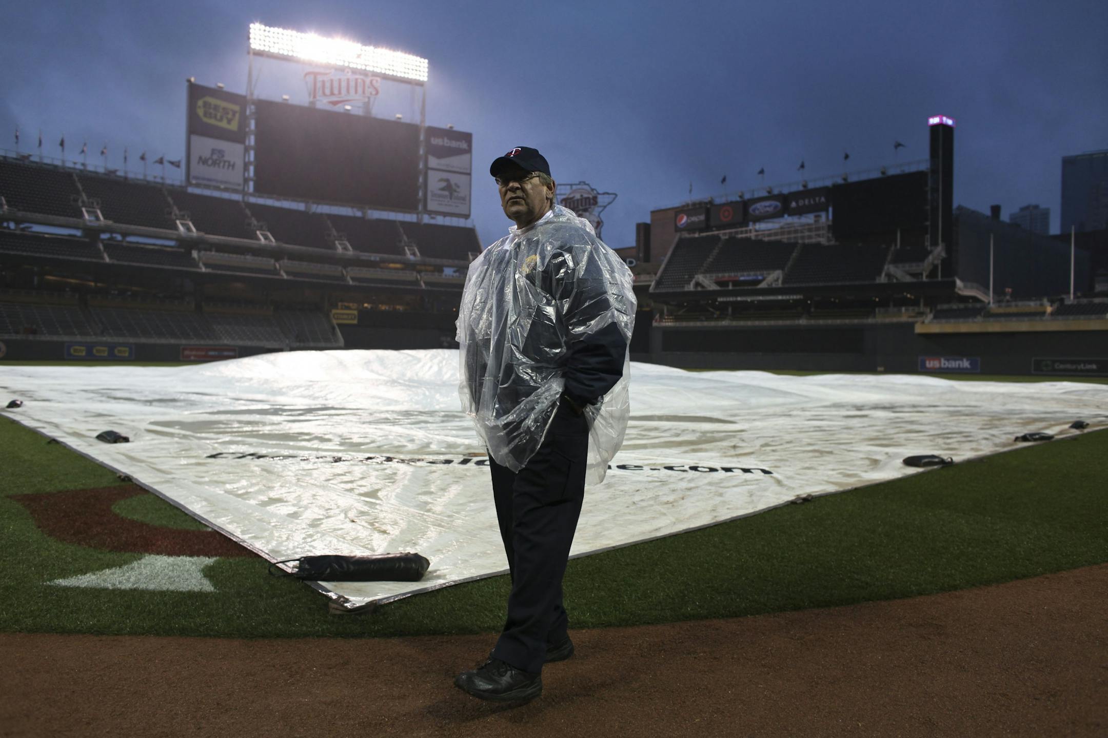 Target Field security guard Joel Charchenko walked the field as he waited for fans to clear out of the park after the game was postpone due to weather. This was the second postponed game in Target Field history.