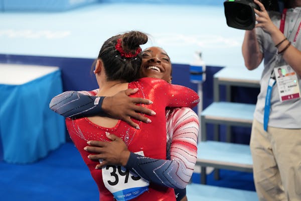 Simone Biles of the United States, right, embraces teammate Suni Lee during the women's balance beam competition at the postponed 2020 Tokyo Olympics 