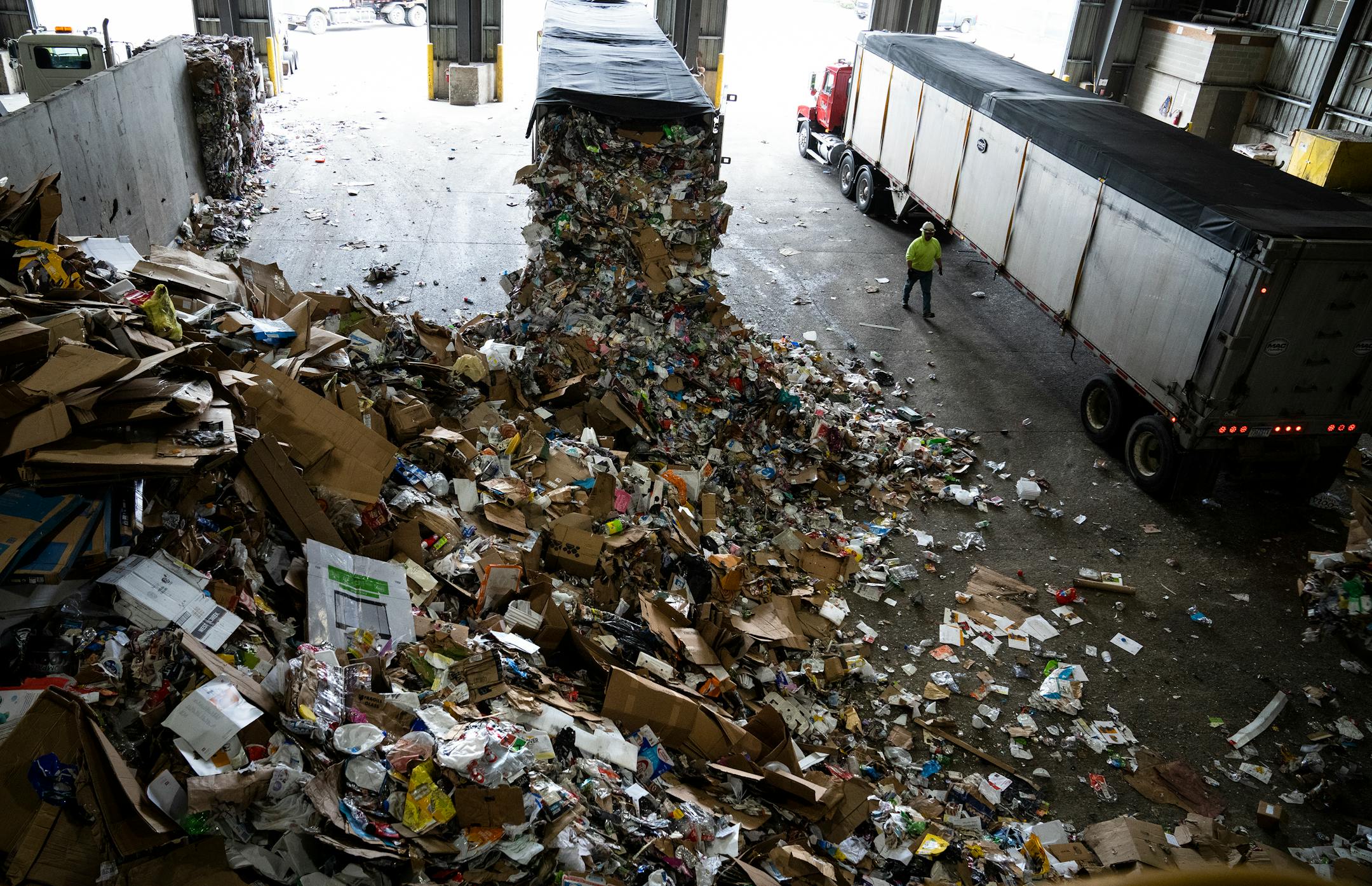 Trucks dump loads of recycling materials inside the single stream recycling facility at Dem-Con Companies Environmental Campus.