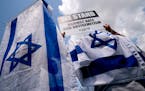 FILE Ñ Activists wear the flag of Israel while holding signs at a rally against antisemitism in Washington on July 11, 2021. After former President D