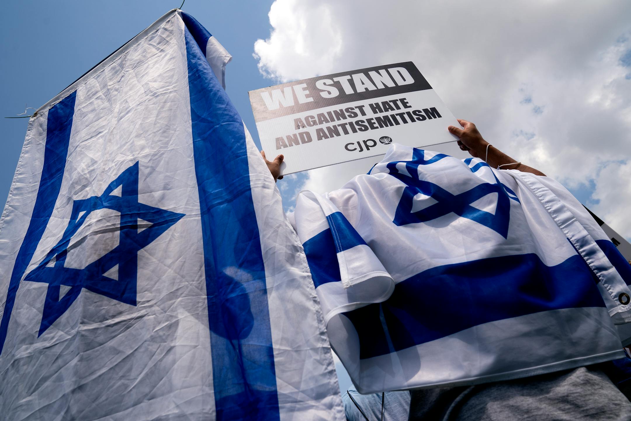 FILE Ñ Activists wear the flag of Israel while holding signs at a rally against antisemitism in Washington on July 11, 2021. After former President Donald Trump dined with the performer Kanye West and with Nick Fuentes, an outspoken antisemite and Holocaust denier, even some of his staunchest supporters say they can no longer ignore the abetting of bigotry by the nominal leader of the Republican Party. (Stefani Reynolds/The New York Times)