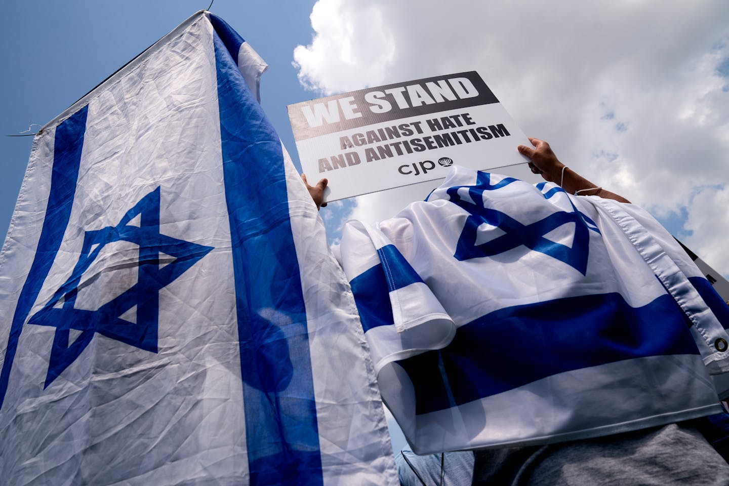 FILE Ñ Activists wear the flag of Israel while holding signs at a rally against antisemitism in Washington on July 11, 2021. After former President Donald Trump dined with the performer Kanye West and with Nick Fuentes, an outspoken antisemite and Holocaust denier, even some of his staunchest supporters say they can no longer ignore the abetting of bigotry by the nominal leader of the Republican Party. (Stefani Reynolds/The New York Times)