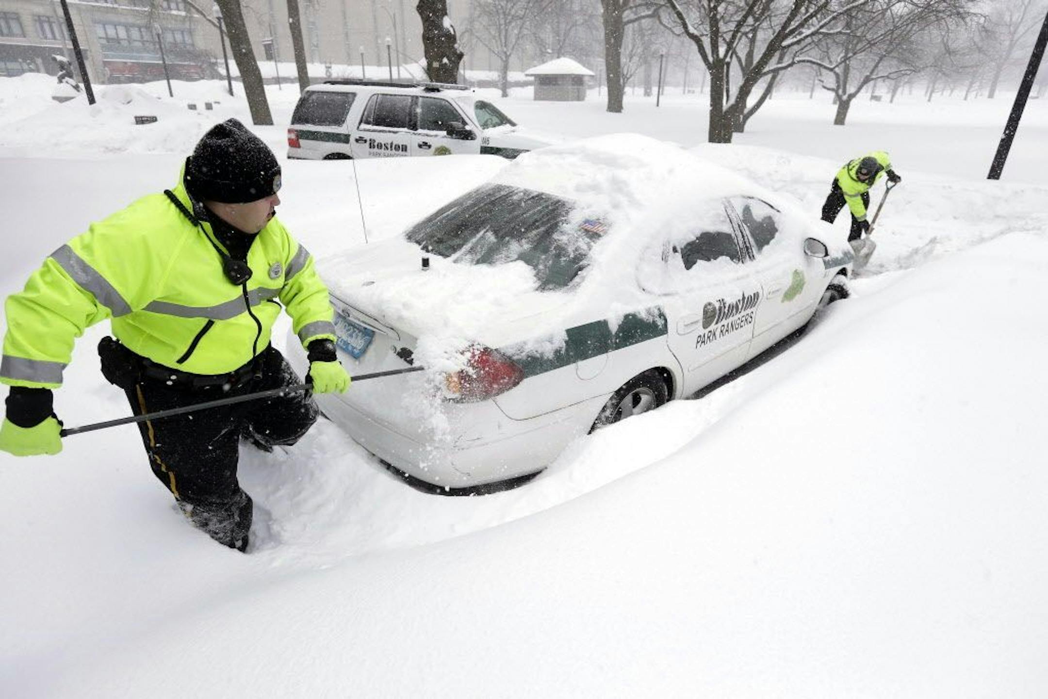 Boston park rangers clear snow from around their car Monday, Feb. 9, 2015, on Boston Common.