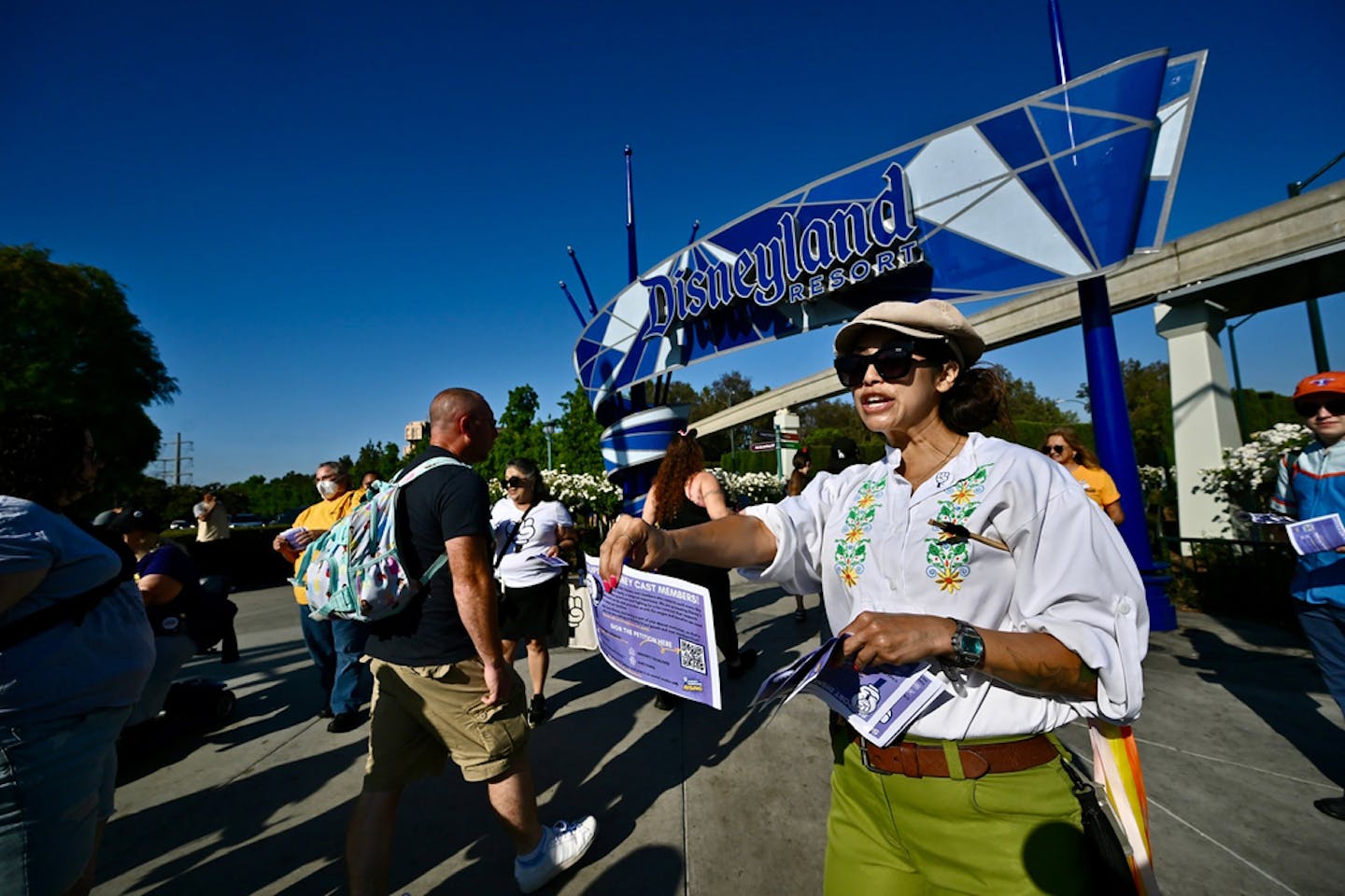 Andi Gallagher, a Fantasyland attractions worker, joins other Disney union members as they pass out buttons and ask visitors to sign a petition suppor