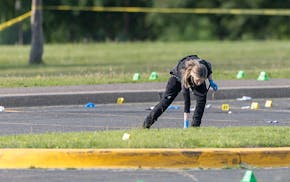 The Minneapolis police forensics division takes in evidence after a shooting that killed one and wounded others at Boom Island Park in Minneapolis on