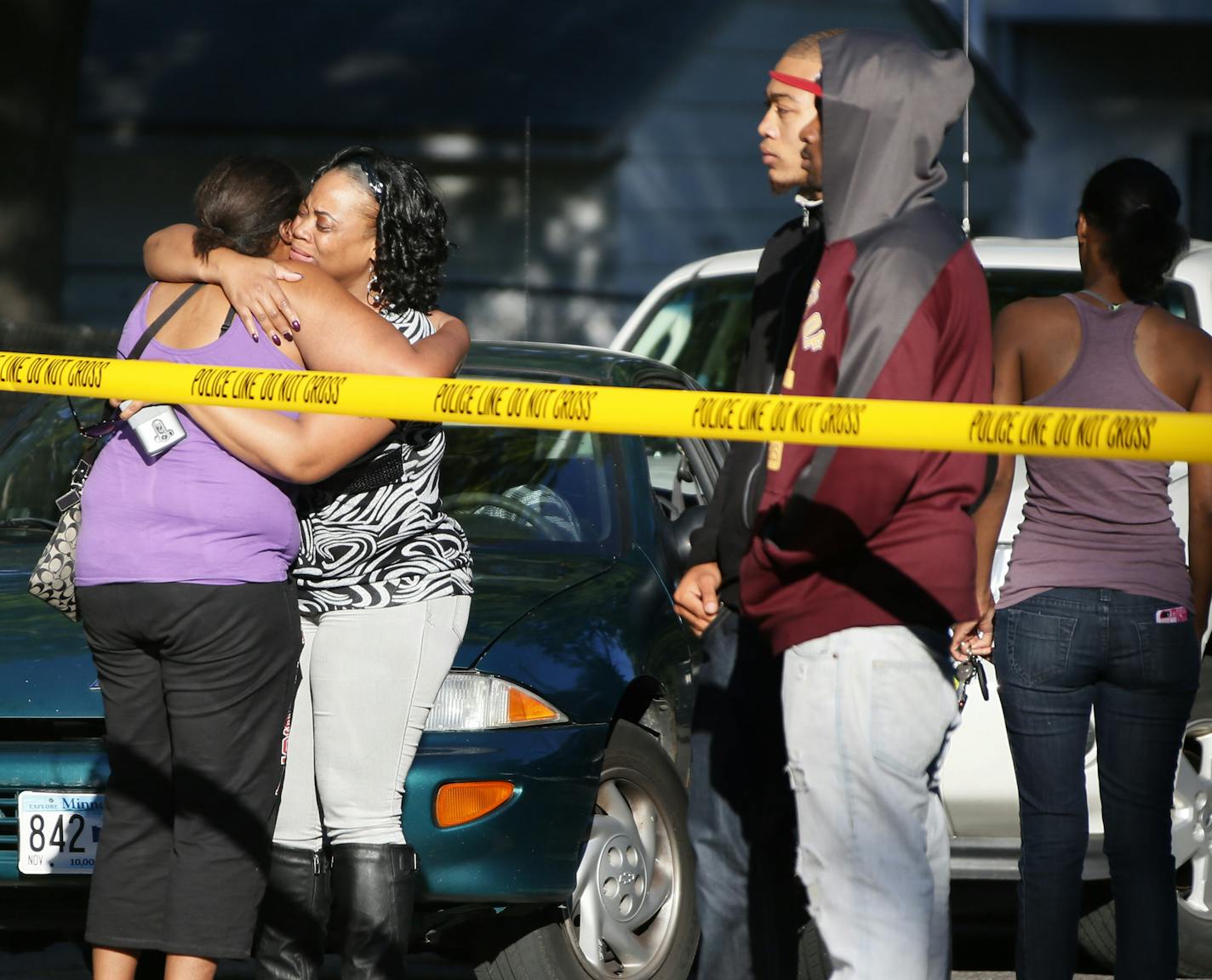 Relatives of a teenager who was shot dead in the 2300 block of Fremont Avenue North gathered near the scene of the shooting Tuesday September 16 , 2014 in Minneapolis ,MN. A second person was as shot during the incident and it was not immediately clear whether those injures were life-threatening . ] Jerry Holt Jerry.holt@startribune.com