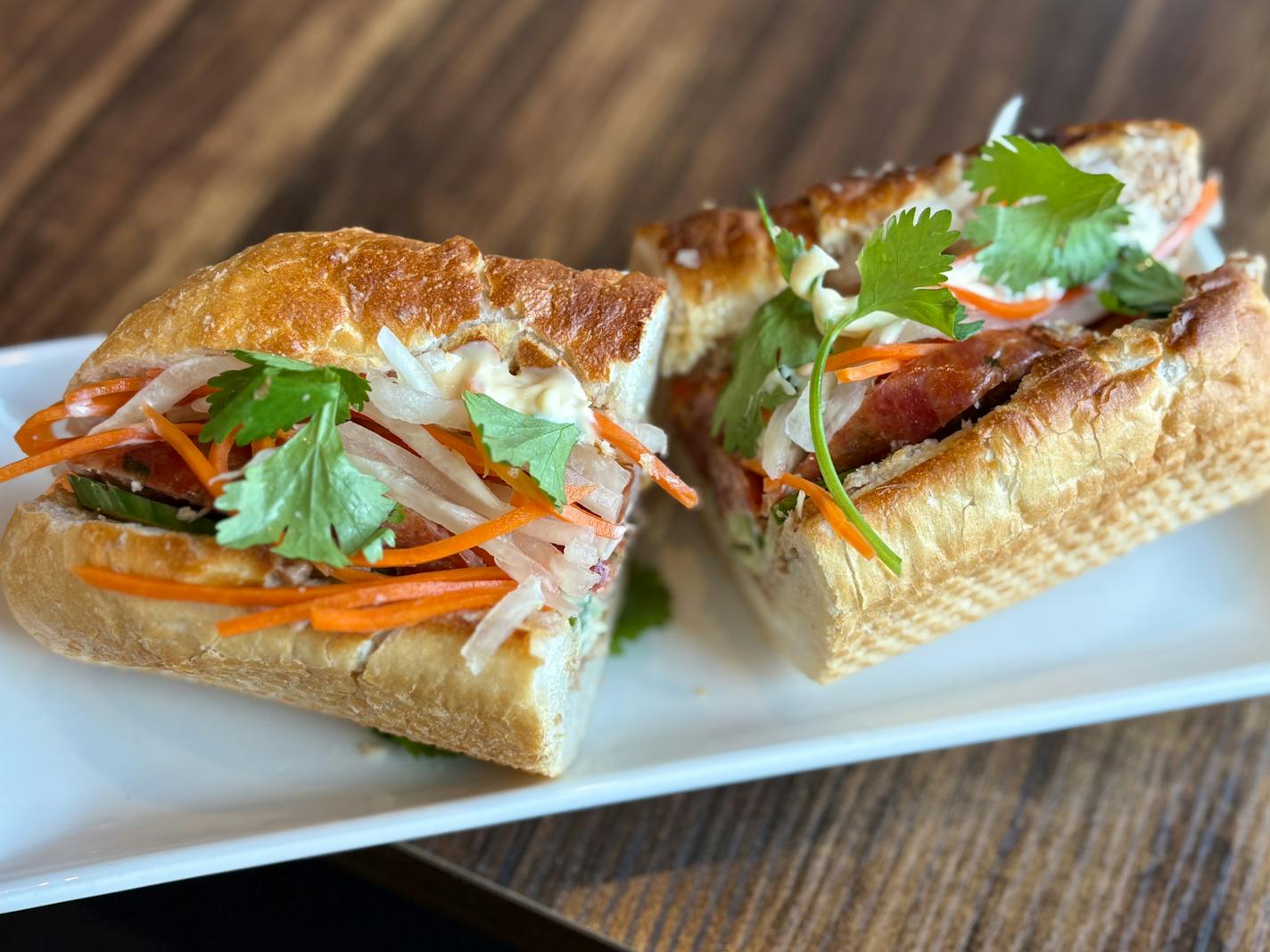Asian Duck in Plymouth's Khao Jee with Lao Sausage. Similar to a banh mi on crusty bread, pickled veggies, house made pate and mroe.