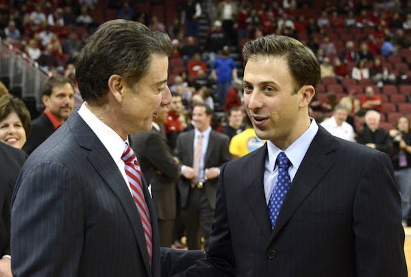 Louisville coach Rick Pitino, left, shakes hands with his son, Richard.
