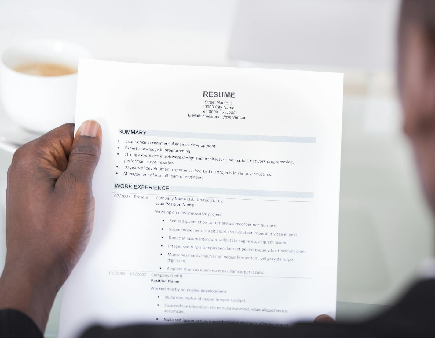 Close-up Of A Businessman Looking At Resume Holding In Hand