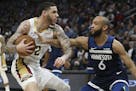 New Orleans Pelicans' Lonzo Ball, left, handles the ball against Minnesota Timberwolves' Jordan McLaughlin in the second half of an NBA basketball gam