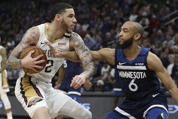New Orleans Pelicans' Lonzo Ball, left, handles the ball against Minnesota Timberwolves' Jordan McLaughlin in the second half of an NBA basketball gam