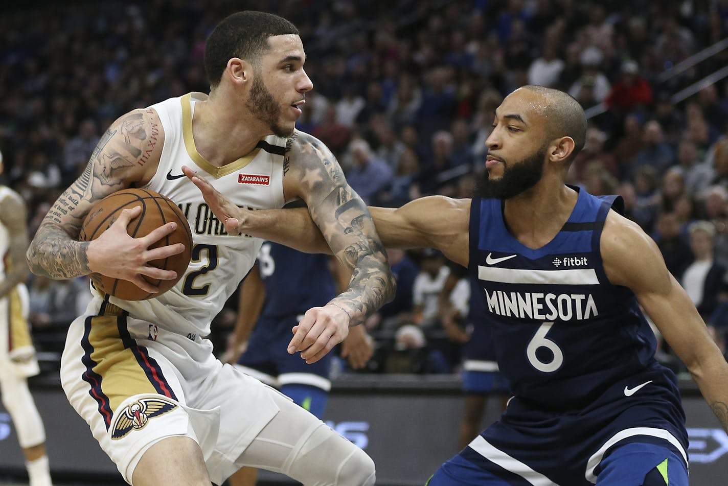 New Orleans Pelicans' Lonzo Ball, left, handles the ball against Minnesota Timberwolves' Jordan McLaughlin in the second half of an NBA basketball game Sunday, March 8, 2020, in Minneapolis. (AP Photo/Stacy Bengs)