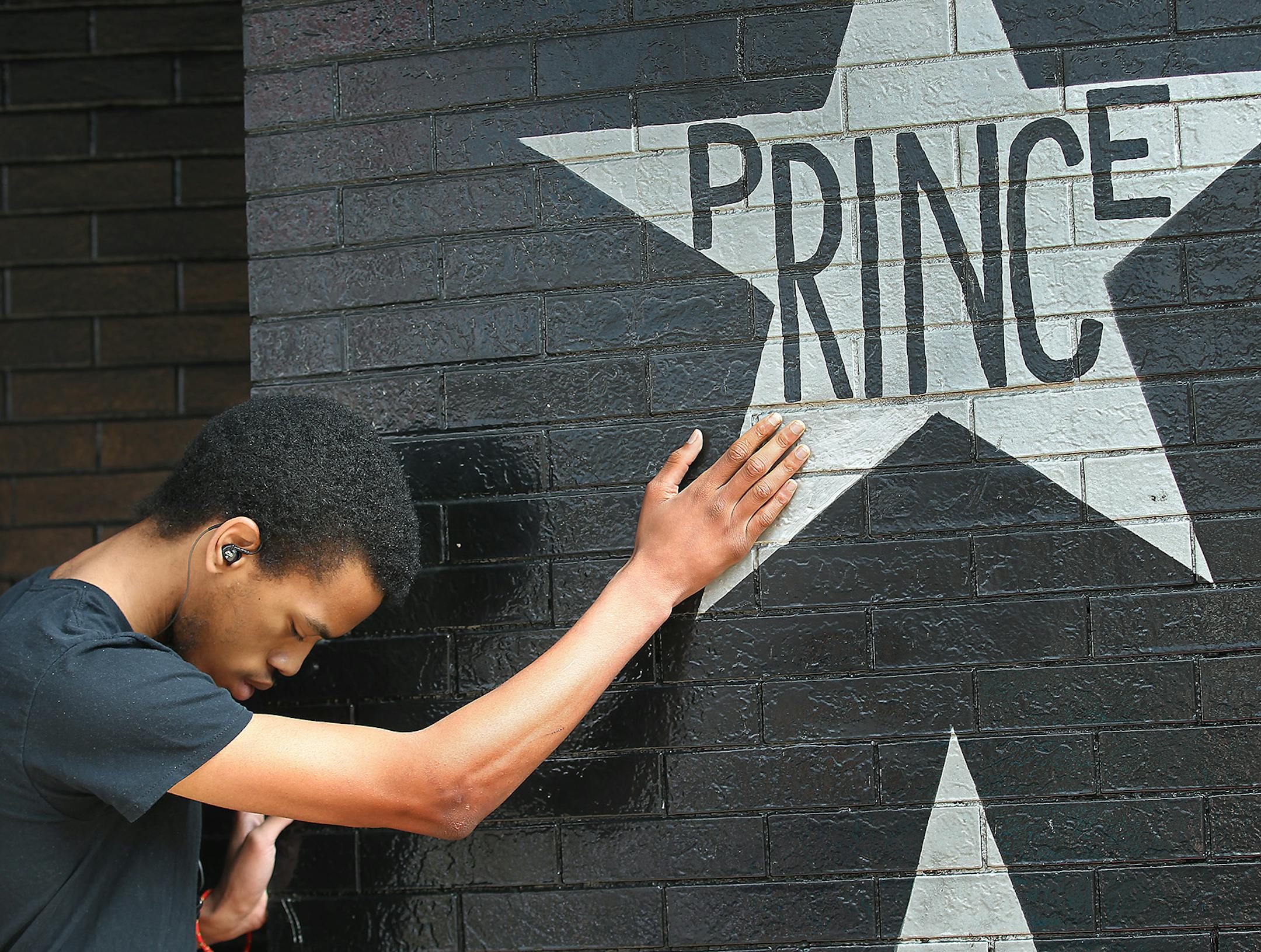 Antonio Carnell, 20, took a moment to touch Prince's star as many gathered at First Avenue after news of his death was made, Thursday, April 21, 2016 in Minneapolis, MN. ORG XMIT: MIN1604211613501747