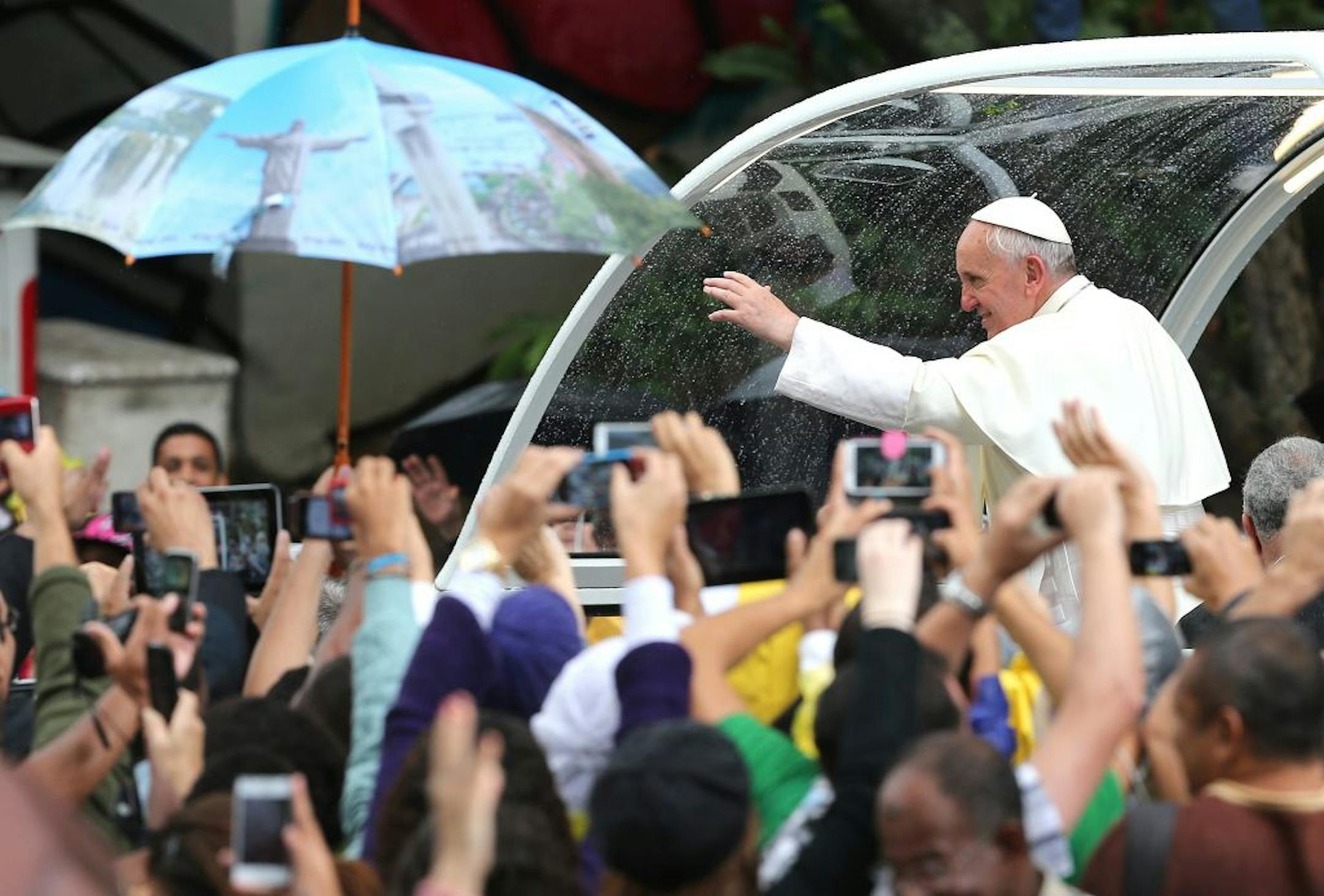 Pope Francis waves to people from his popemobile in Rio de Janeiro, Brazil, Saturday, July 27, 2013. Pope Francis on Saturday challenged bishops from around the world to get out of their churches and preach, and to have the courage to go to the farthest margins of society to find the faithful.