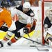 The Philadelphia Flyers' Claude Giroux, left, tries to shoot against Anaheim Ducks goalie Frederik Anderson and Ryan Kesler (17) during the first peri