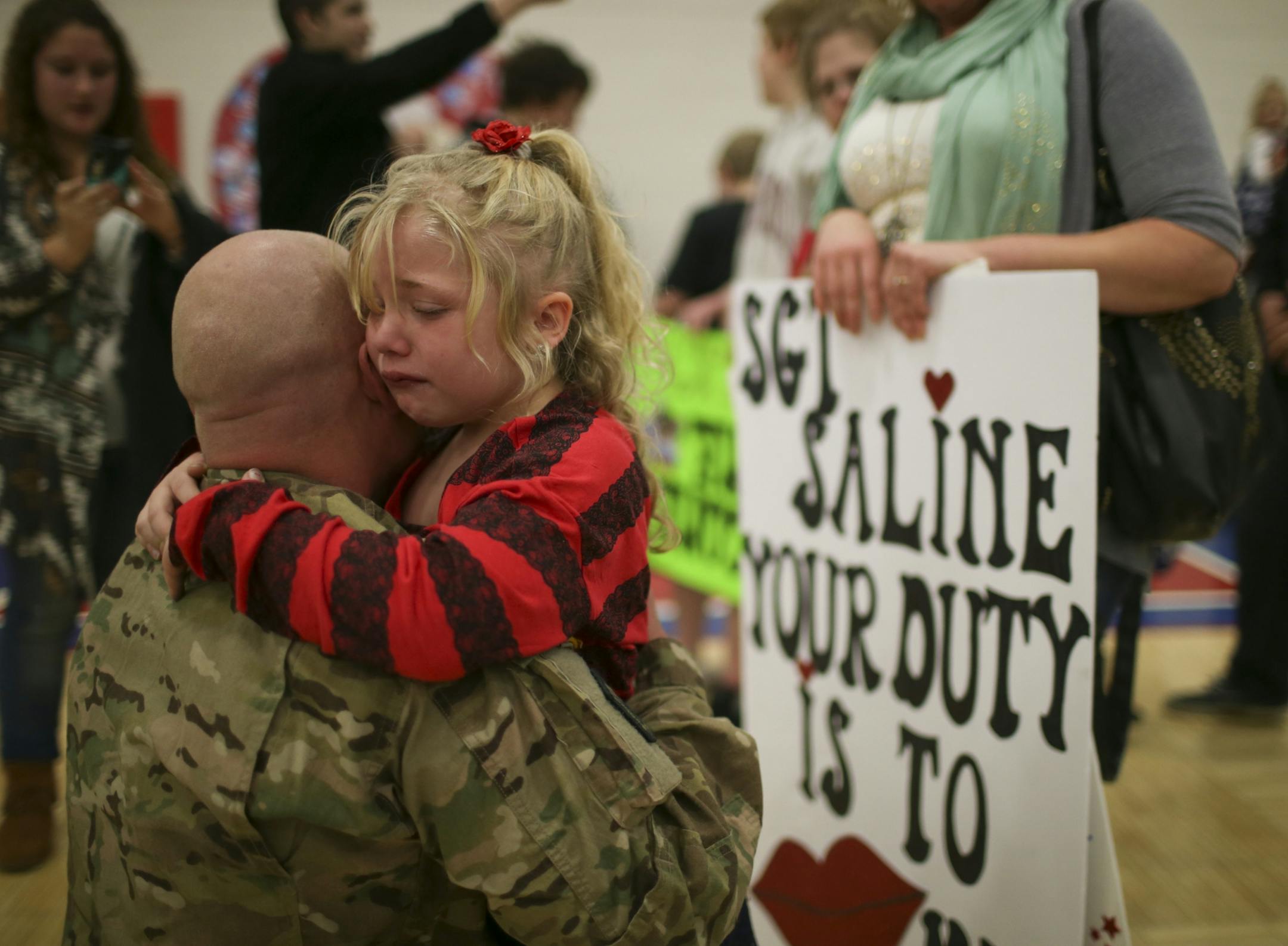 Members of the Cambridge-based 850th Horizontal Engineer Company of the MInnesota National Guard returned home to their loved ones after an eight month deployment in Afghanistan Sunday afternoon, December 22, 2013. The 140 soldiers were met by their families in the gym at Cambridge-Isanti High School. Layla Saline, 6, held onto her dad, Terry, at their reunion in the high school gym Sunday afternoon.