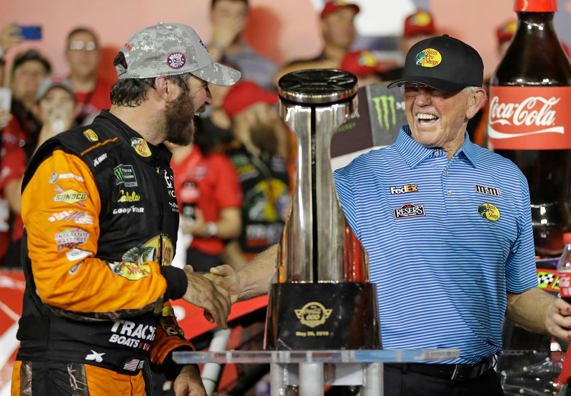 Martin Truex Jr., left, was congratulated by team owner Joe Gibbs in Victory Lane after winning the NASCAR Cup Series race at Charlotte Motor Speedway in Concord, N.C., on Sunday.