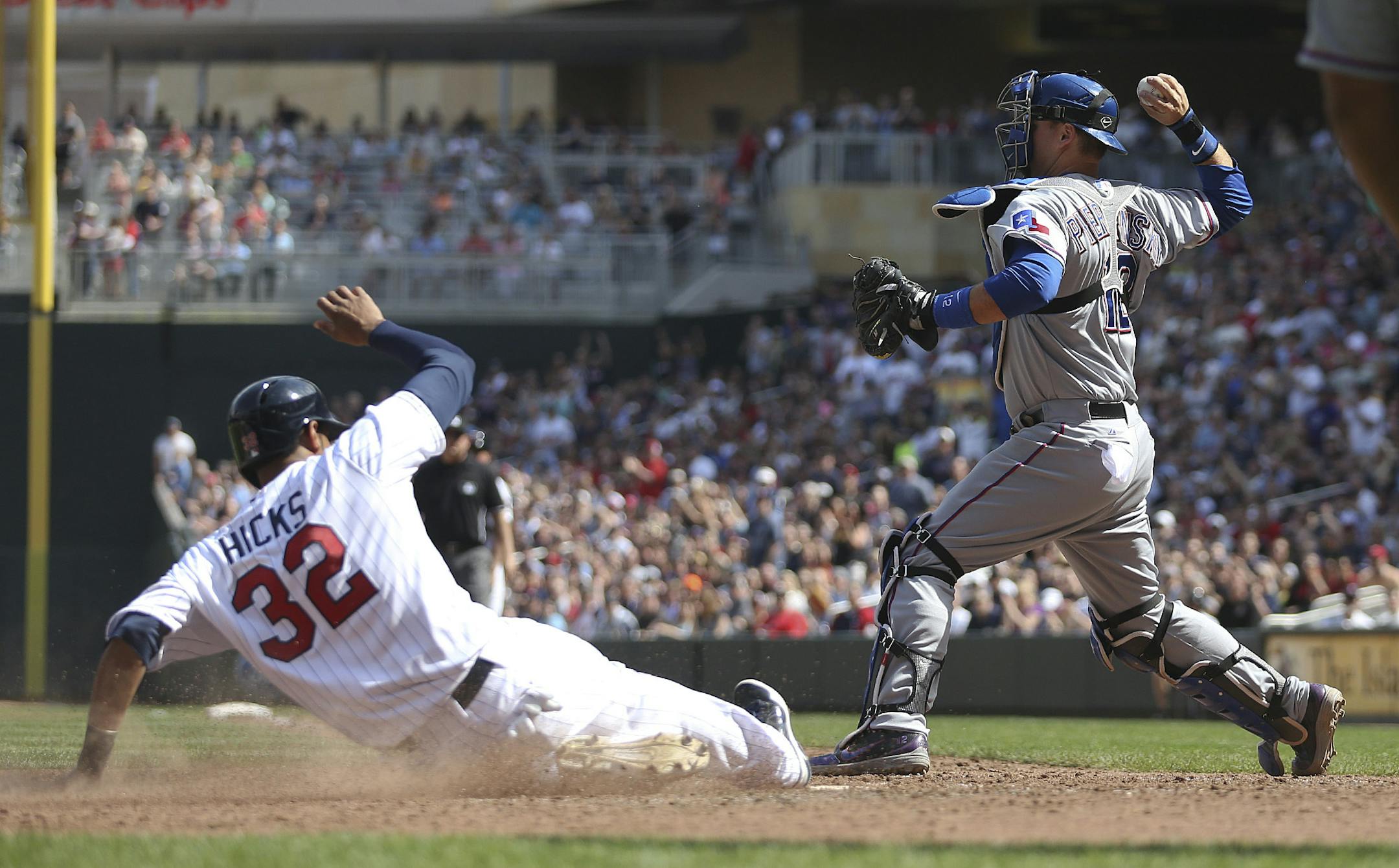 Aaron Hicks #32 of the Minnesota Twins slid into to home safe as A.J. Pierzynski #12 of the Texas Rangers came up throwing to third in the seventh inning at Target Field in Minneapolis Min., Sunday, April 28, 2013. Twins won 5-0 over Texas. ] (KYNDELL HARKNESS/STAR TRIBUNE) kyndell.harkness@startribune.com