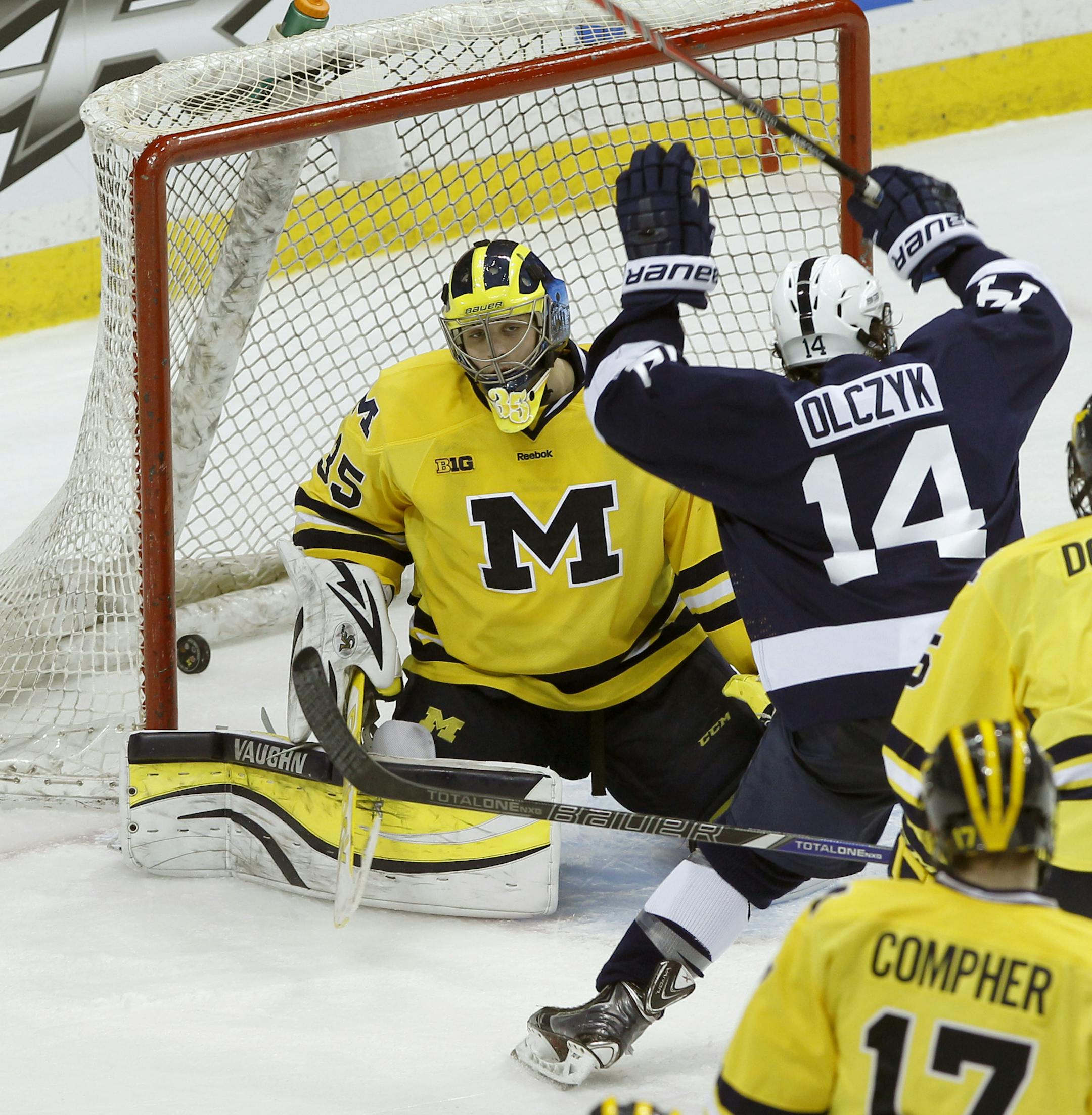 Penn State forward Tommy Olczyk (14) begins to celebrate as the game-winning shot by teammate Zach Saar gets past Michigan goalie Zach Nagelvoort, left, during the second overtime of an NCAA college hockey game in the Big Ten Conference tournament in St. Paul, Minn., Thursday, March 20, 2014. Penn State won 2-1 in double overtime. (AP Photo/Ann Heisenfelt)