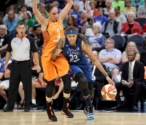 The Minnesota Lynx's Seimone Augustus (33) dribbles by the Phoenix Mercury's Diana Taurasi (3) during the first quarter at the Target Center in Minnea