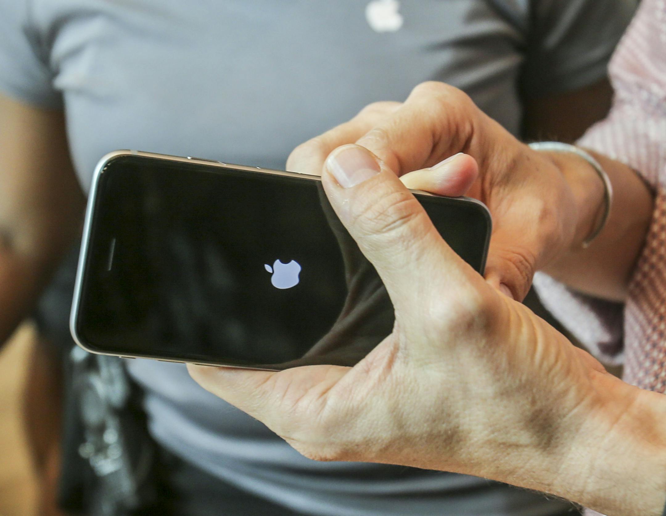 FILE - In this Sept. 25, 2015 file photo, a customer tries out his Apple iPhone 6s smartphone at the Apple store at The Grove in Los Angeles. Apple reports quarterly financial results on Tuesday, Oct. 27, 2015. (AP Photo/Ringo H.W. Chiu, File)
