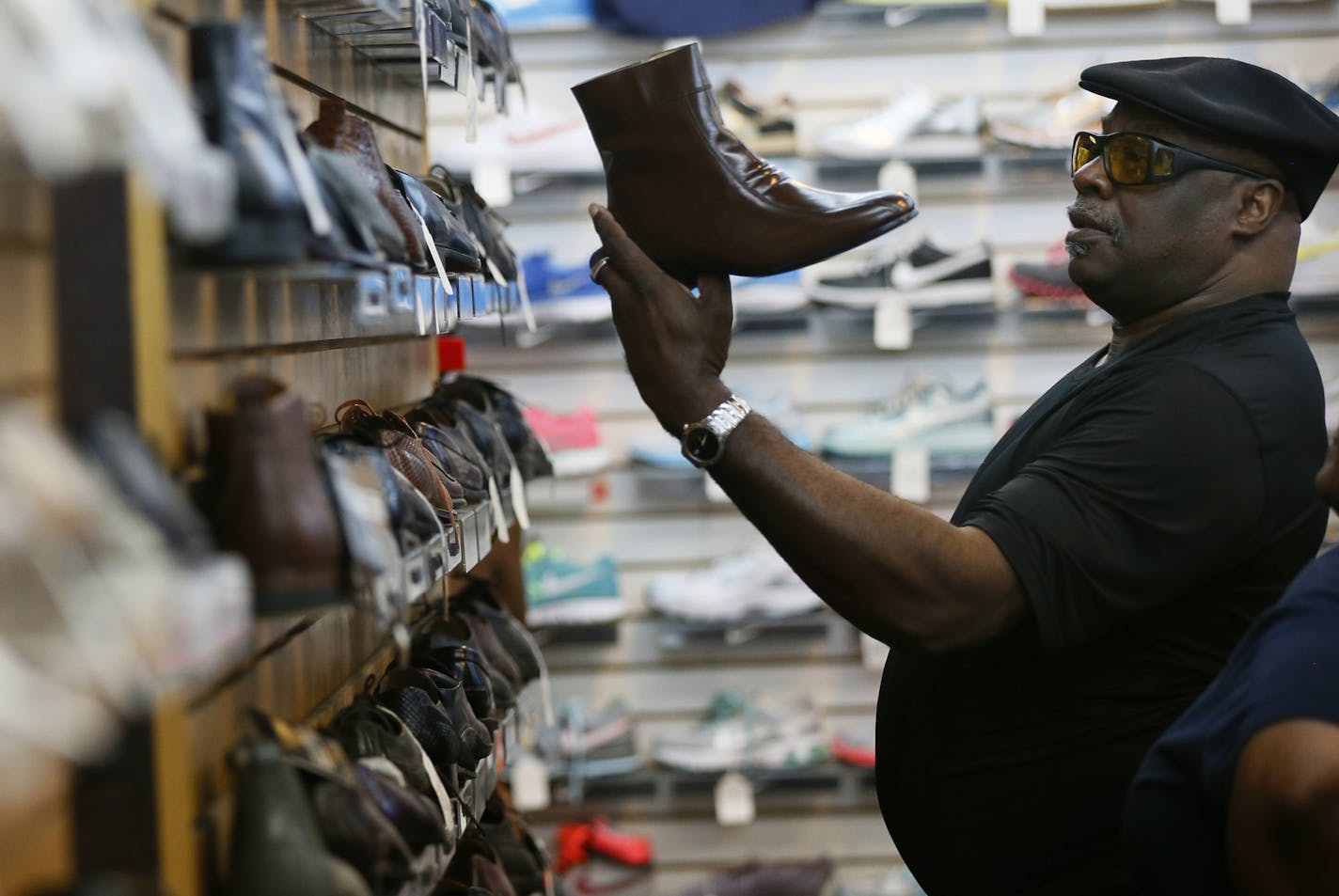 Tyrone Douglas a customer at Roberts Shoe store since the sixties checked out a pair of boots MondayAugust 4 , 2014 in Minneapolis , MN . Roberts Shoe store a mainstay at Chicago and Lake street is is closing after 77 years .] Jerry Holt Jerry.holt@startribune.com