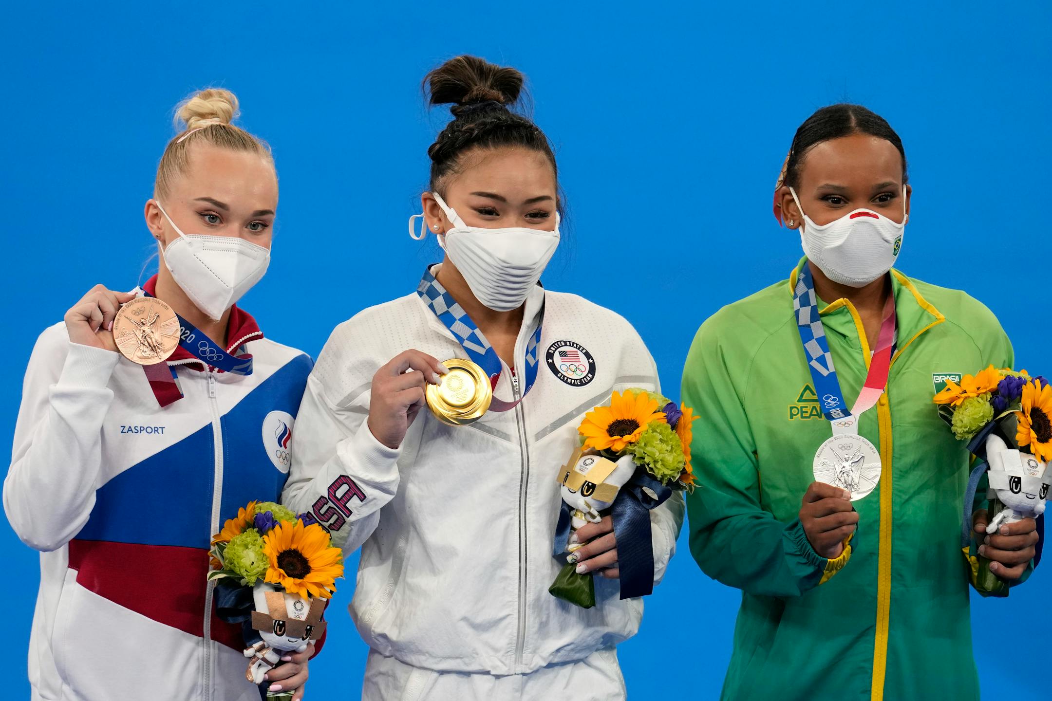 From right to left, silver medallist Brazil's Rebeca Andrade, Gold medallist Suni Lee of the Unites States, and bronze medalist Angelina Melnikova, of the Russian Olympic Committee, celebrate during the medal ceremony for the artistic gymnastics women's all-around at the 2020 Summer Olympics, Thursday, July 29, 2021, in Tokyo. (AP Photo/Natacha Pisarenko)