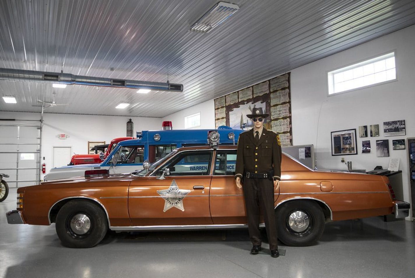 The deputy sheriff's squad car still sits on display in the Settler's Square Historical Museum with all original damage, along with a mannequin dressed in uniform.